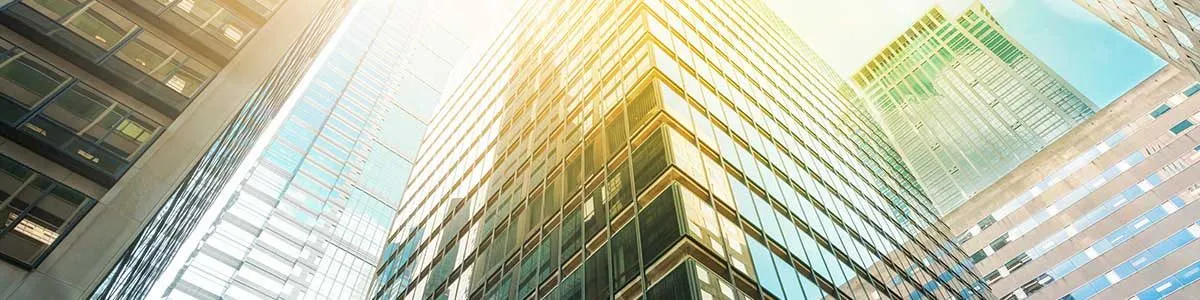 Glass office towers rising in bright sunlight
